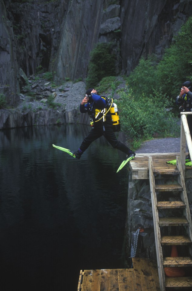 Scuba diver jumping into a quarry lake.