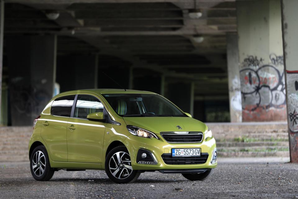 Lime green Peugeot 108 parked in a parking garage.