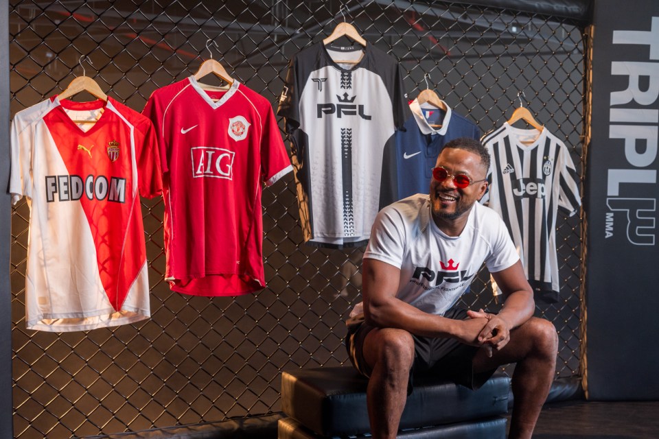 Patrice Evra sitting in front of several soccer jerseys.