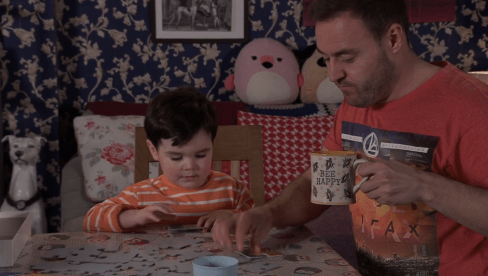A father and son doing a jigsaw puzzle together.