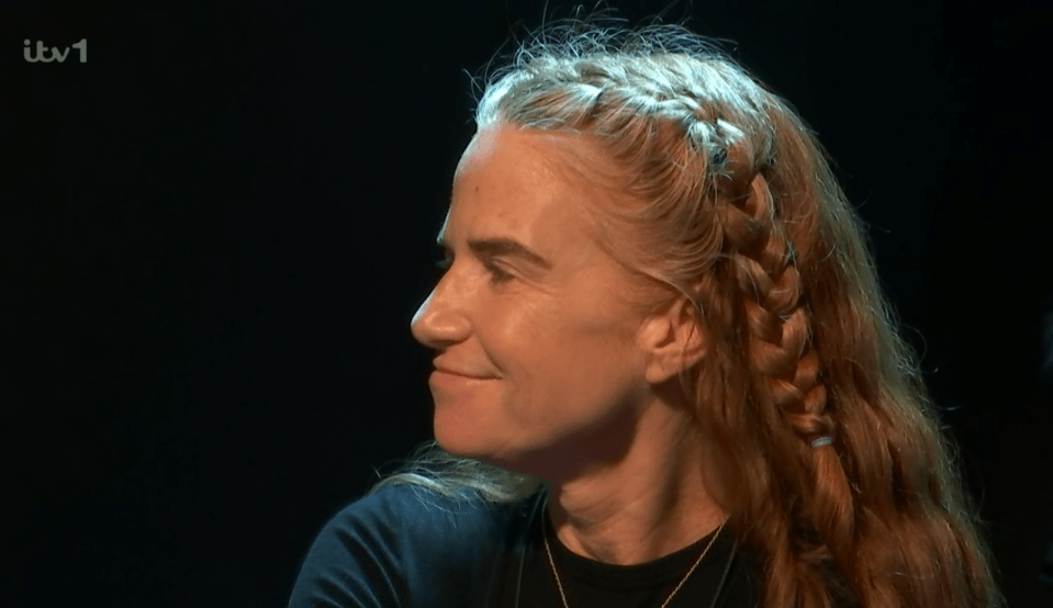 Screenshot of a woman with long blonde hair styled in braids.