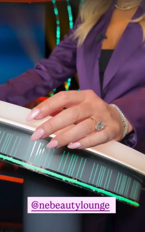 Amanda Holden's hand on a game show control.