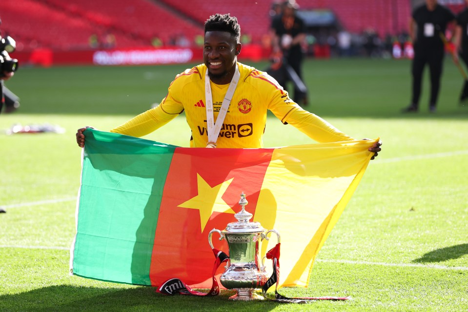 Andre Onana of Manchester United celebrates with the FA Cup trophy and the Cameroonian flag.