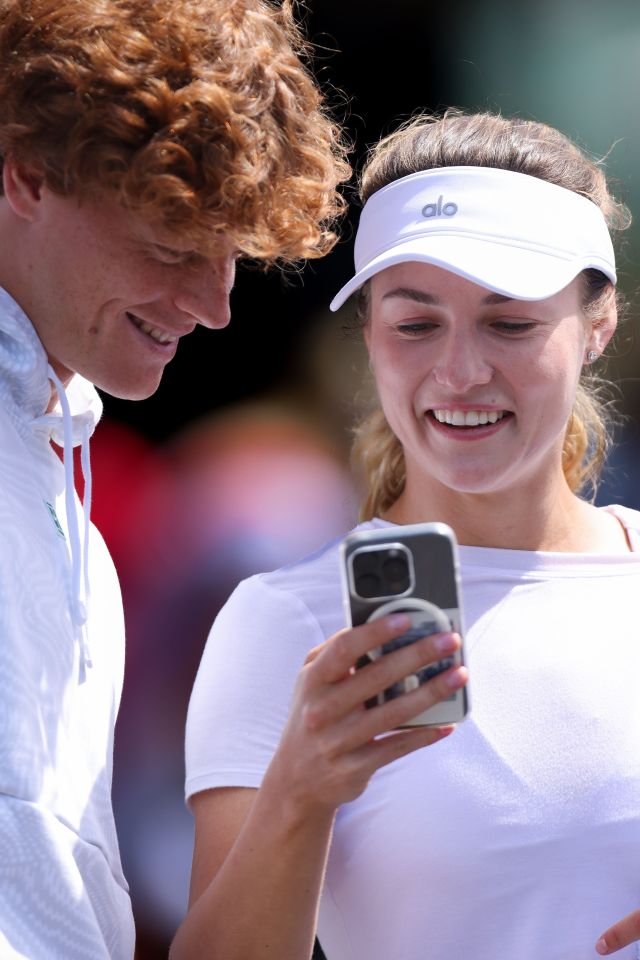 Jannik Sinner and Anna Kalinskaya looking at a smartphone.