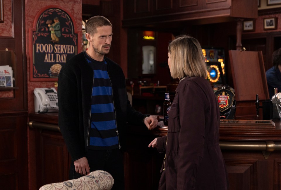 A man and woman talking at a pub bar.