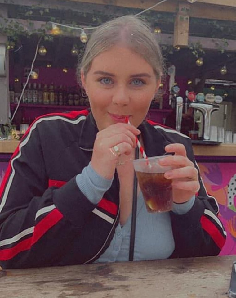 Woman drinking from a cup with a straw.