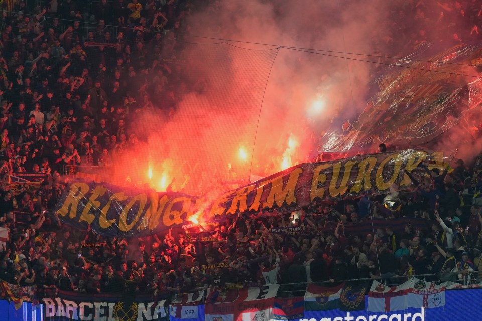 Barcelona soccer fans holding up flares and a banner that says "Reconquerim Europa" (Reclaim Europe).