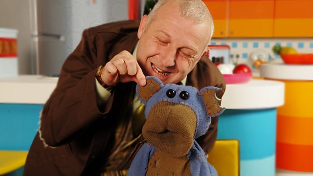 Man playfully interacting with a sock puppet.