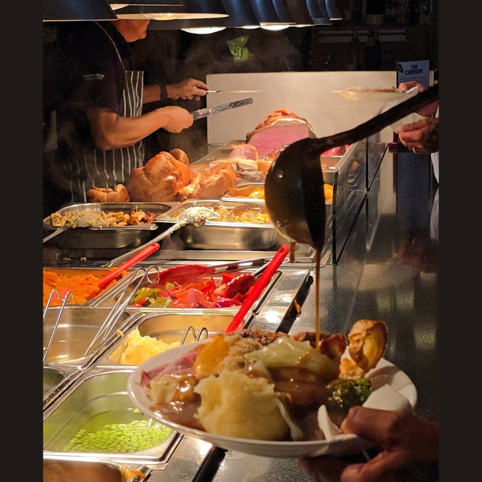 A carvery station with various meats, vegetables, and gravy.