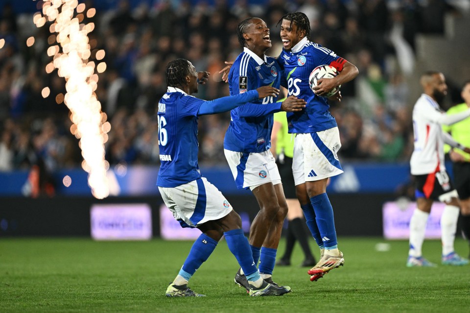 Three Strasbourg soccer players celebrating a victory.