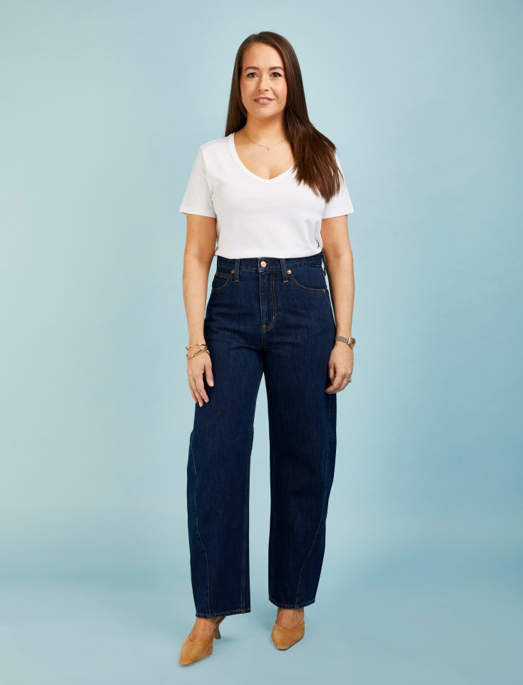Woman in white shirt and dark wash jeans.