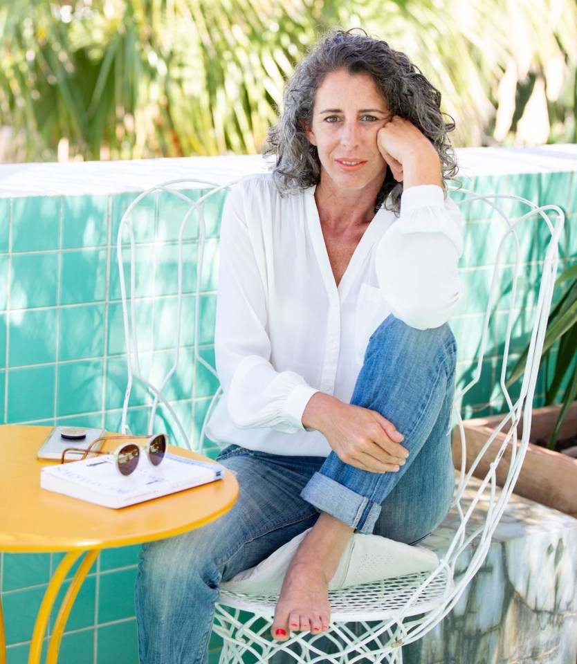 Woman sitting outdoors in a white chair.
