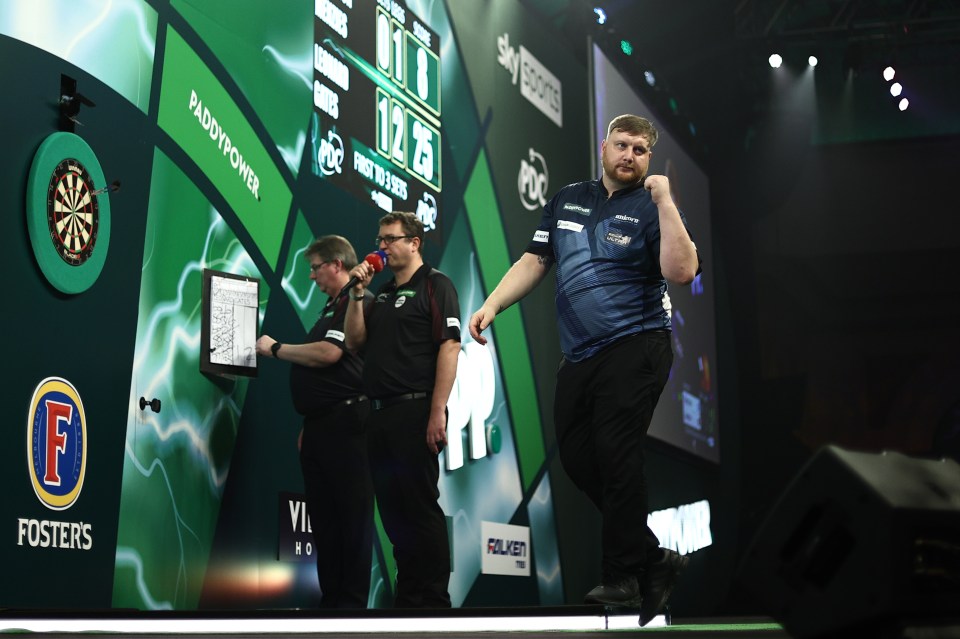 Cameron Menzies celebrates during a darts match.