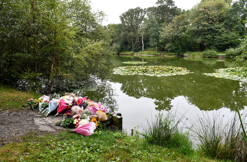 Floral tributes by a pond.
