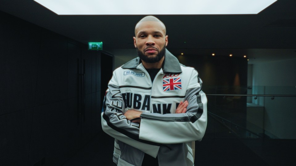 Chris Eubank in a white jacket with his arms crossed.
