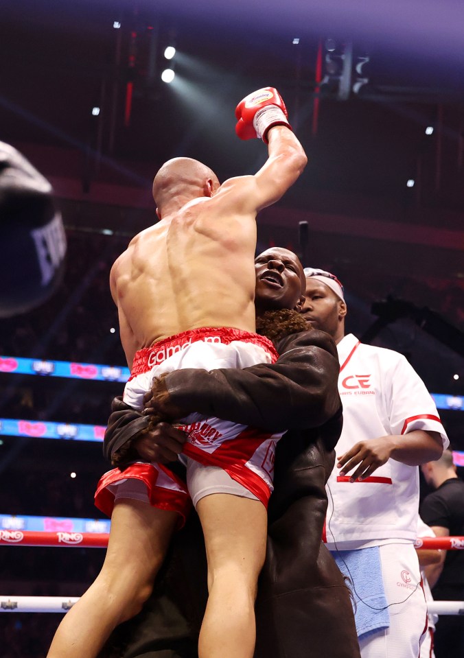 Chris Eubank Jr. being lifted by his father after a boxing match victory.