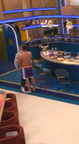 Chris Hughes and JoJo Siwa embracing in a brightly lit kitchen.