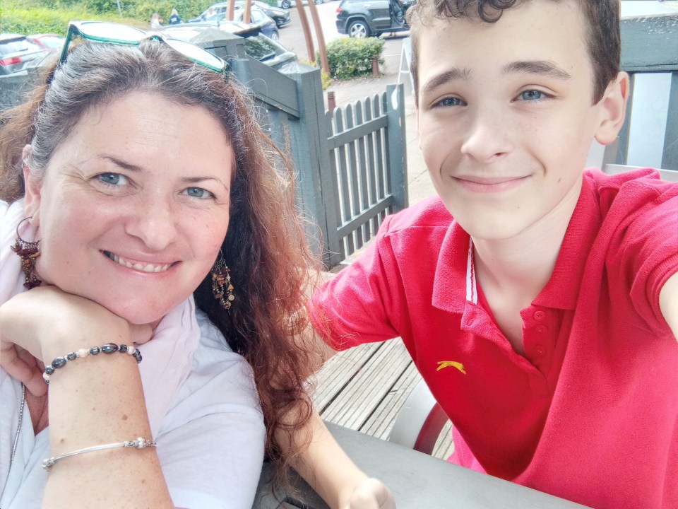 A mother and her teenage son smiling for a selfie.