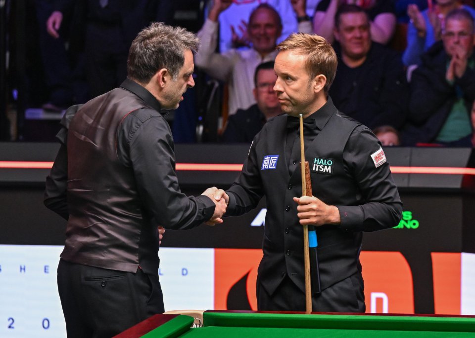 Ronnie O'Sullivan and Ali Carter shaking hands after a snooker match.