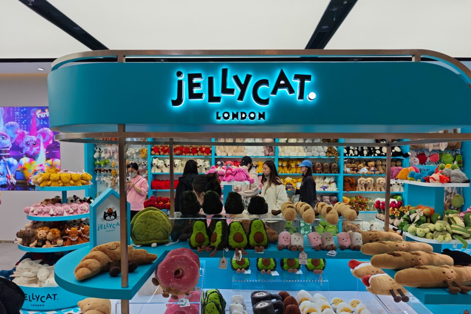 Customers shopping at a Jellycat London store filled with stuffed animals.