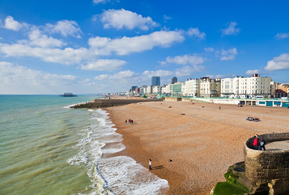 Brighton beach with people and buildings in the background.