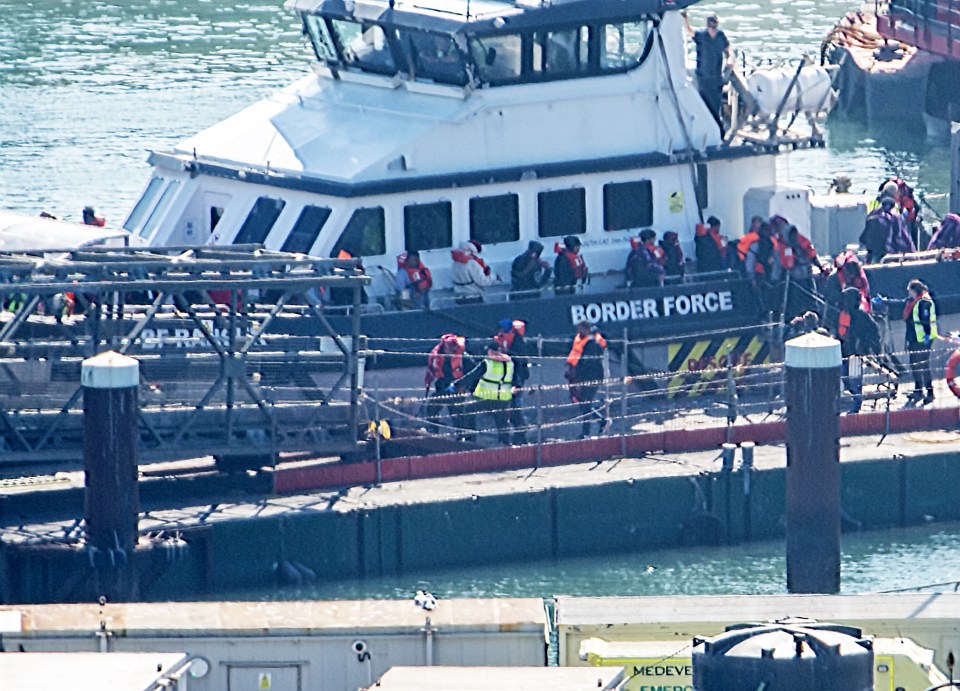 Migrants arriving at Dover Docks, UK, escorted by Border Force.