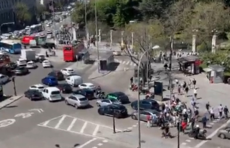Aerial view of a busy city intersection with cars and pedestrians.