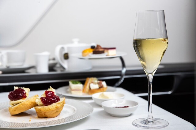 First-class airline meal service with scones, pastries, and champagne.