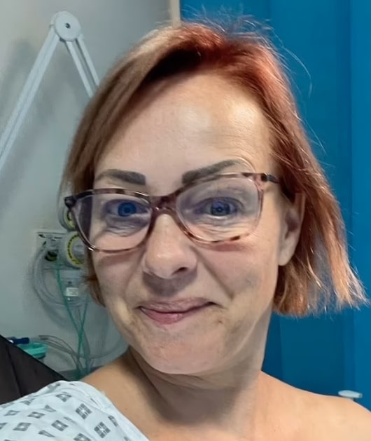 Close-up of Sarah Cawood in a hospital gown.