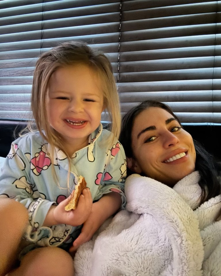 A woman and her young daughter cuddling.