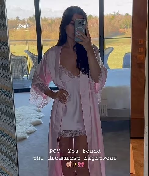 Woman in pink silk robe and matching slip.