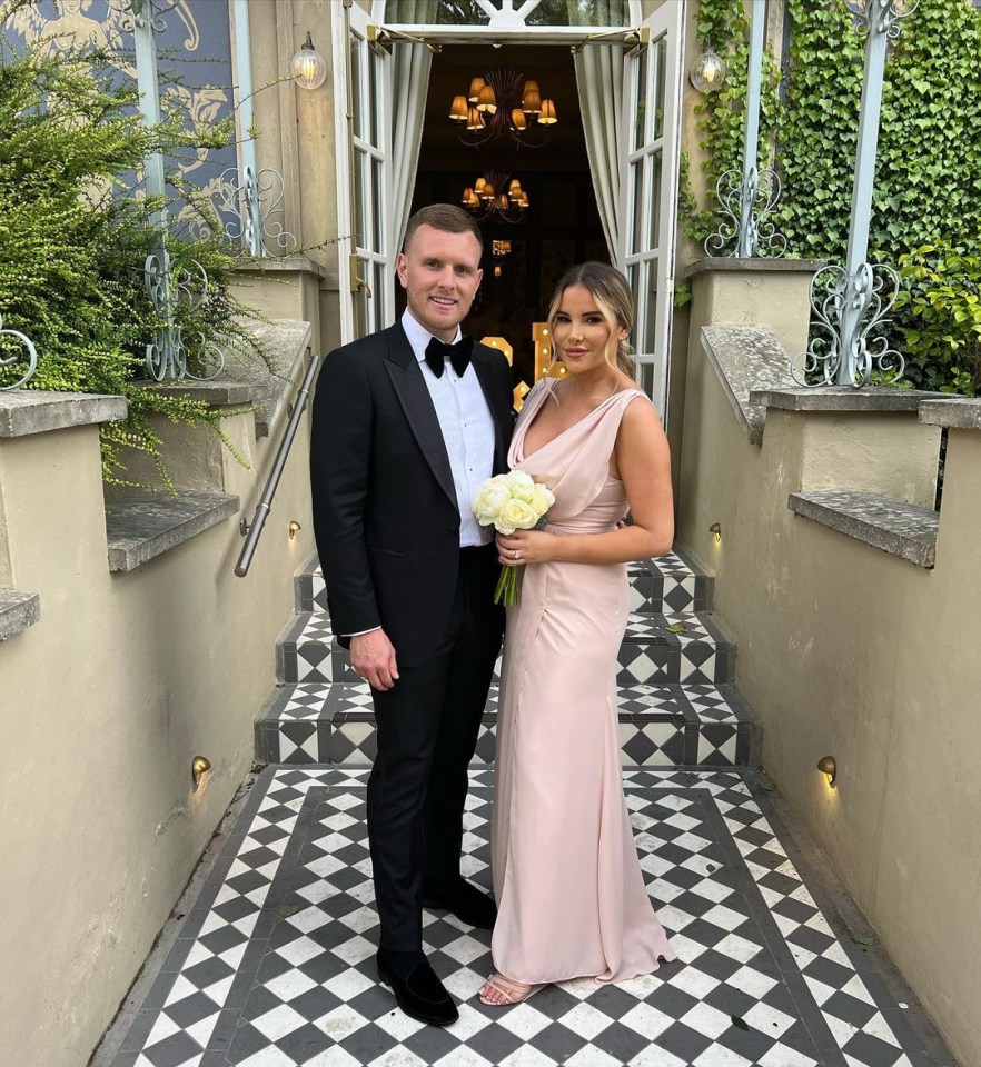 Georgia Kousoulou and Tommy Mallett on steps outside a building.