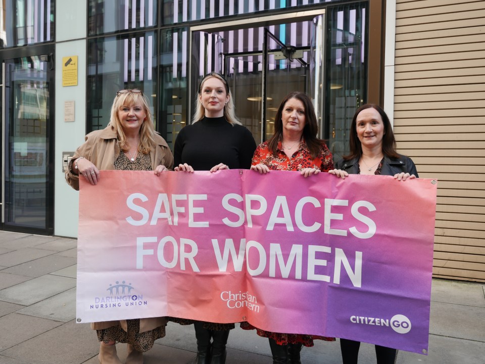 Four nurses holding a banner that reads "Safe Spaces for Women".