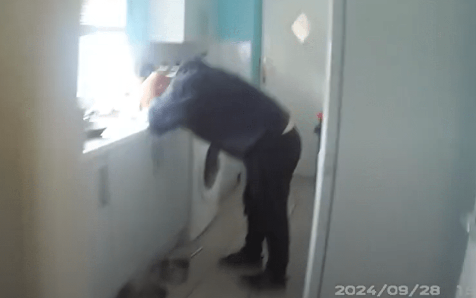 Man bending over in a kitchen.