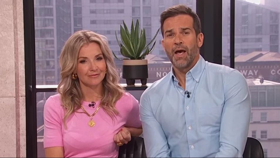 Two television presenters sitting side-by-side.
