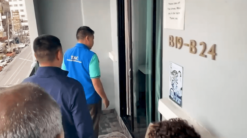People standing on a balcony outside a room numbered B19-B24.