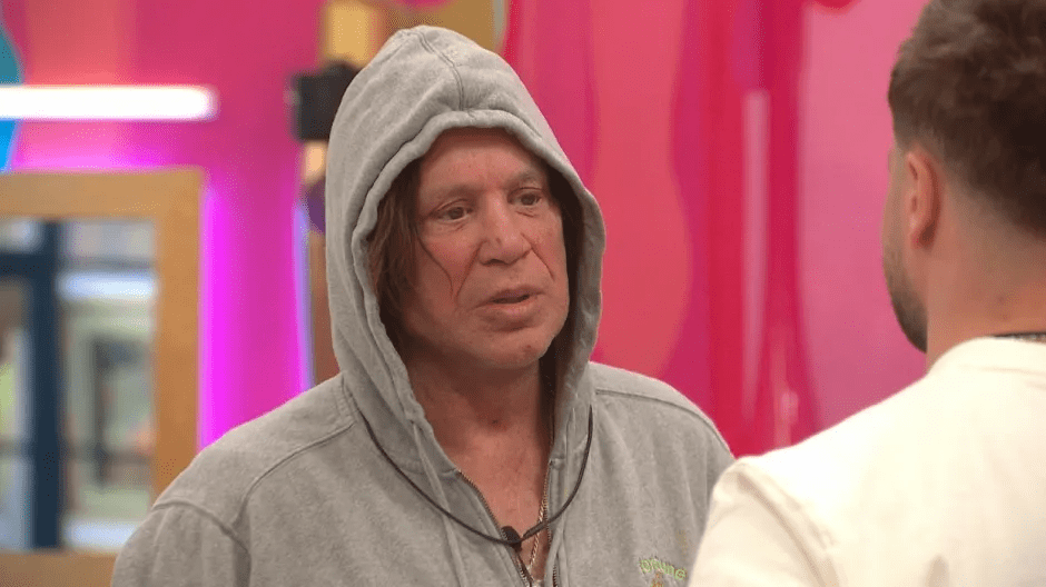 Man in gray hoodie talking to another man.