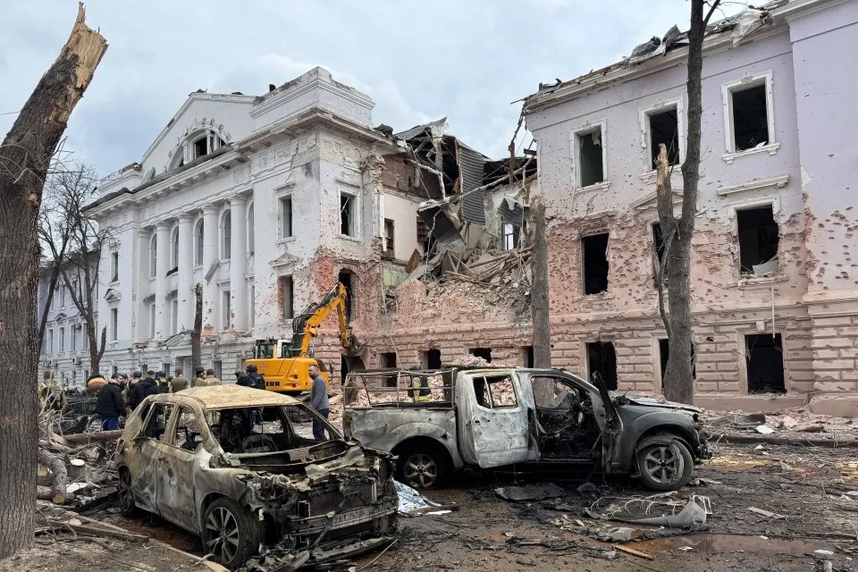 Burned-out cars and a damaged building.