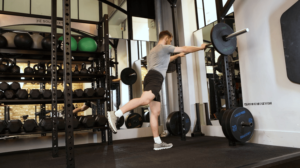 Man performing a leg exercise in a gym.