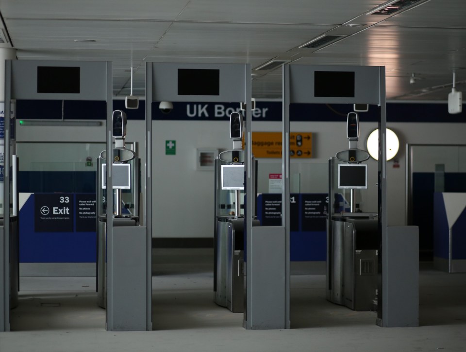 Empty UK Border Control gates at an airport.
