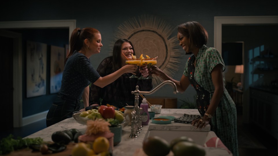 Three women from Sweet Magnolias toasting with margaritas.