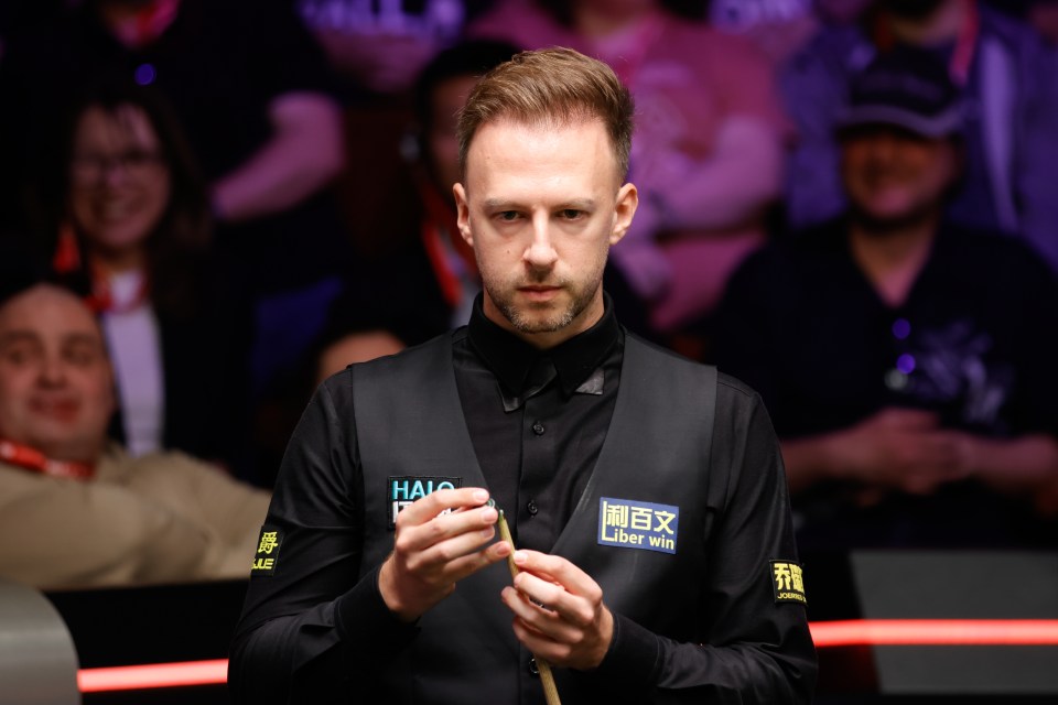 Judd Trump chalking his cue.