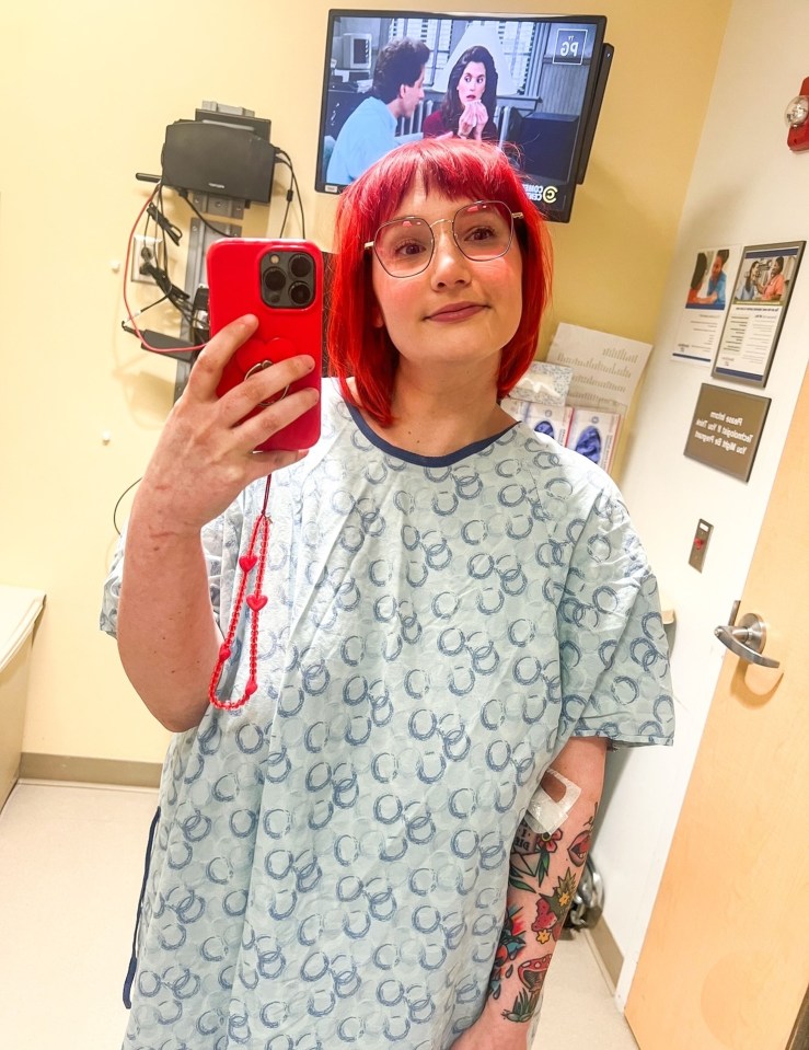 Woman in hospital gown taking a selfie.