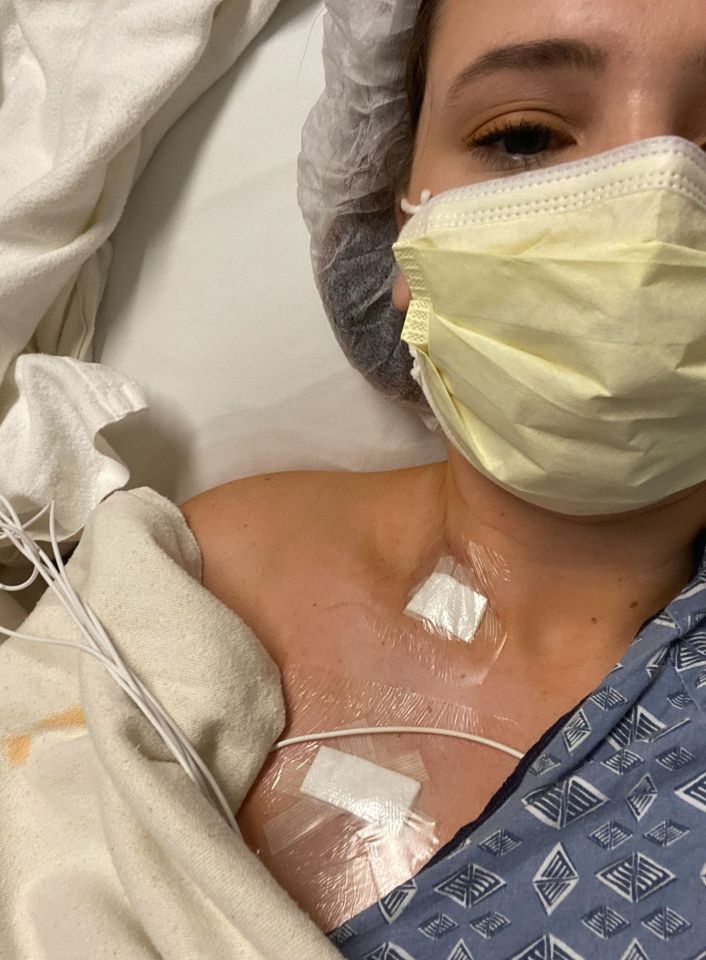 Close-up of a woman in a hospital bed with medical patches on her chest.