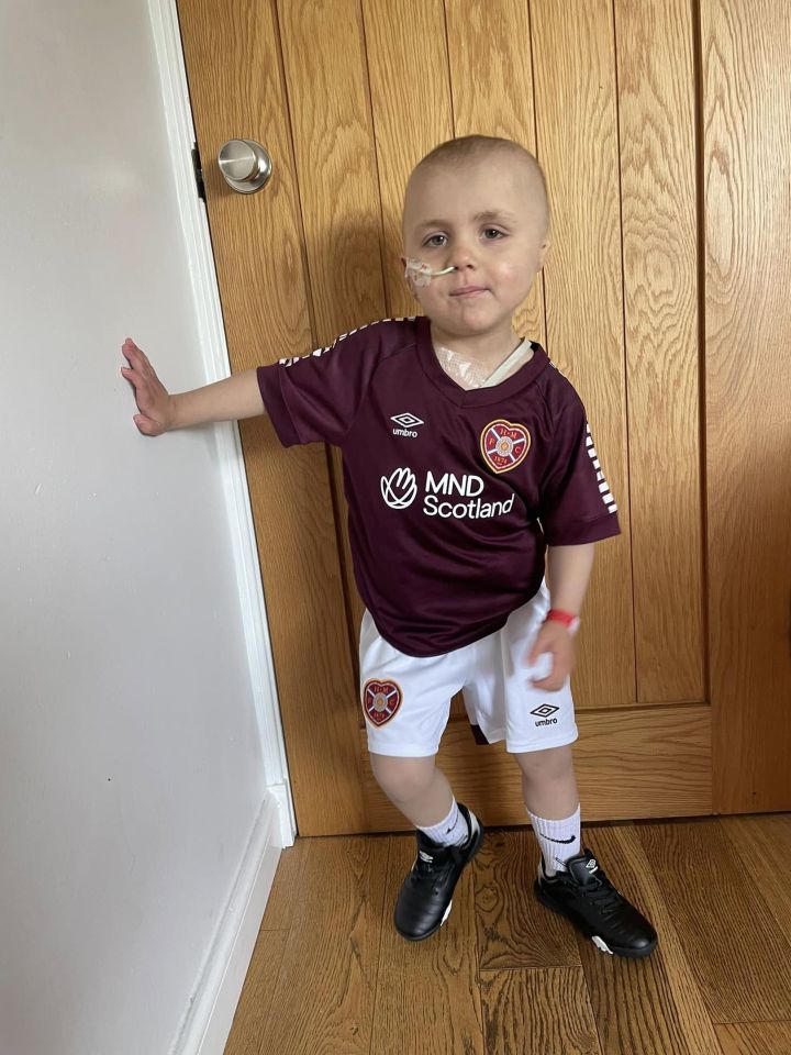 Young boy with leukaemia wearing a football kit.