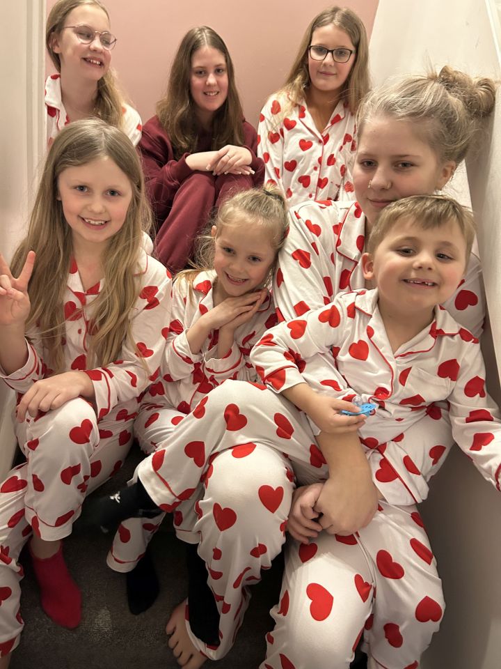 Eight children in red heart pajamas.