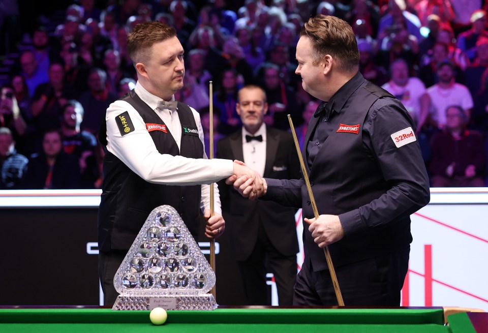 Kyren Wilson and Shaun Murphy shaking hands before a snooker match.