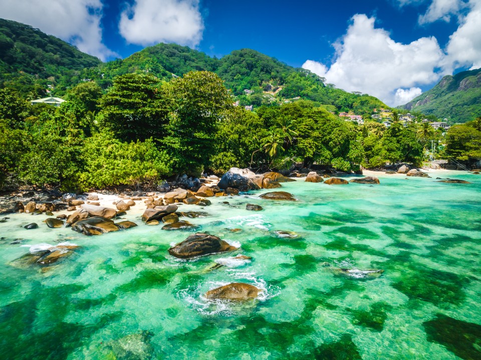 Tropical island beach with granite rocks and turquoise water.