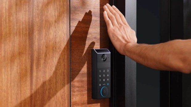 Hand unlocking a smart door lock with palm recognition.