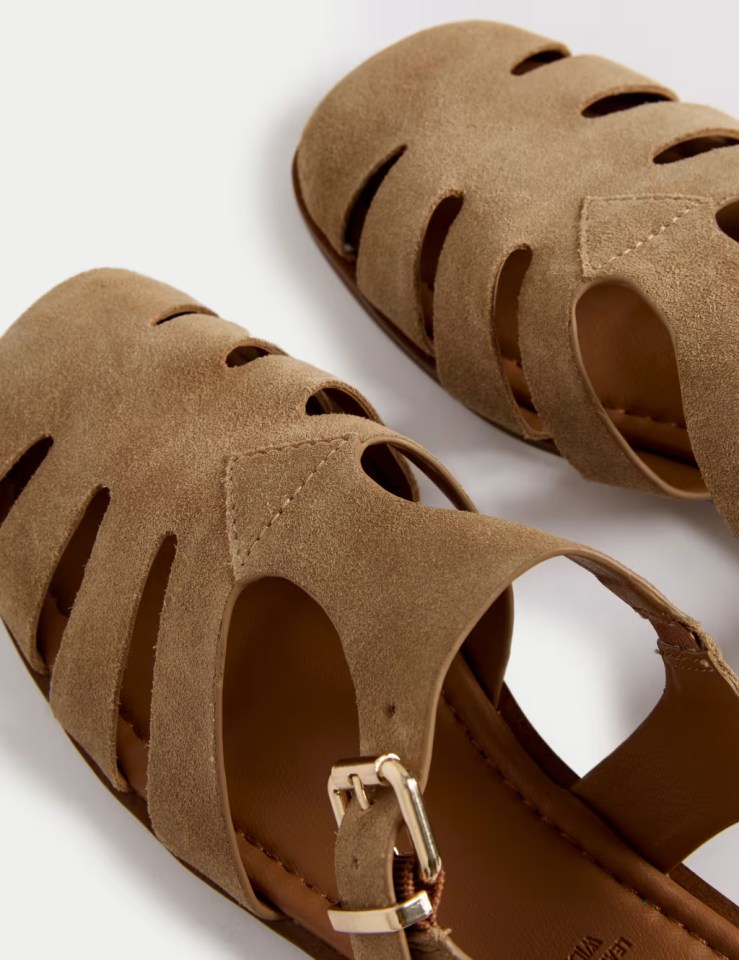 Close-up of a pair of brown suede sandals with cut-out details.